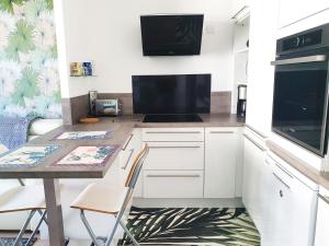 a kitchen with white cabinets and a table with a microwave at EXIGEHOME-Bel appartement de standing-30 minutes de Paris in Vélizy-Villacoublay