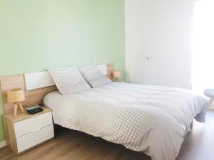 una camera con un grande letto bianco e un comodino di EXIGEHOME-Bel appartement de standing-30 minutes de Paris a Vélizy-Villacoublay