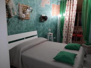 a bedroom with a large bed with green walls at Suites Florence in Pescara
