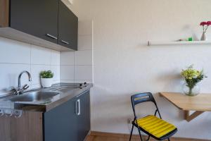 eine Küche mit einer Spüle und einem Stuhl neben einem Tisch in der Unterkunft Blankwasserweg 131 Lensterstrand Oase Bungalow 3 in Lenste
