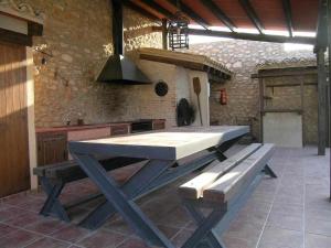 a large picnic table in a kitchen with a stove at Casas Rurales Venta Seca hasta 24 plazas in El Romero