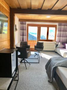 a bedroom with a bed and two chairs and windows at Haus Hubertus Pitztal Winterbuchung für Wintersaison oder Sommerbuchung mit Sommercard möglich in Jerzens