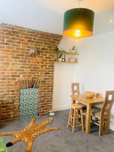 a dining room with a table and a brick wall at Funky 2 Bedroom Apartment In Town Centre in Hastings