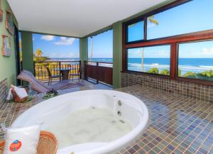 a bath tub in a room with a view of the ocean at Vivá Porto de Galinhas Resort in Porto De Galinhas