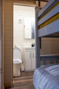 a bedroom with a bed and a bathroom with a toilet at The Buzzard - 6 Person Family Glamping Cabin in Dungarvan