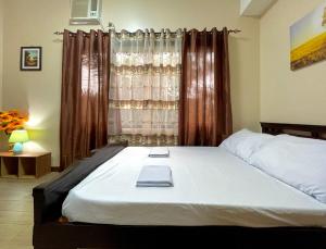 a bedroom with a bed and a window with curtains at Paseo Verde Condominium 1 Bedroom for 6 pax in Manila