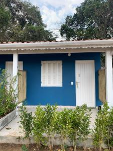 a blue and white house with two windows at Suítes Maresias in São Sebastião