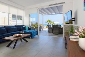 salon z niebieską kanapą i stołem w obiekcie Villa Aphrodisia - Seafront w Ajia Napa