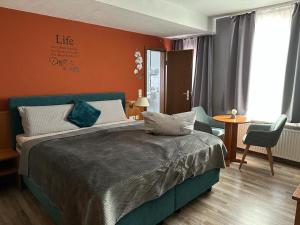 a bedroom with a large bed and a living room at Hotel Oberledinger Hof in Leer