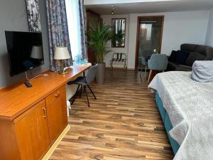 Schlafzimmer mit einem Bett und einem Schreibtisch mit einem TV in der Unterkunft Hotel Oberledinger Hof in Leer