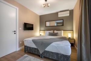 a bedroom with a large bed and a mirror at Ciragan Bosphorus Apartments in Istanbul