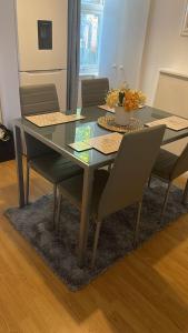 uma mesa de jantar e cadeiras com uma mesa de vidro e cadeiras em Coral Place em Luton