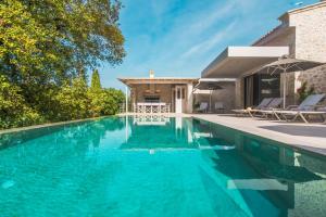 コントカリにあるMy Mediterranean Corfu Luxury Villa with Private Swimming Poolの家の前の青い水のスイミングプール