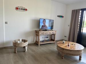 - un salon avec une télévision et une table dans l'établissement Haamaire, à Bora Bora