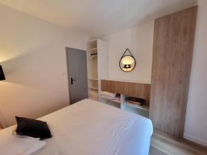 a small bedroom with a white bed and a mirror at Chaleureux 2 pièces au centre de Haguenau in Haguenau