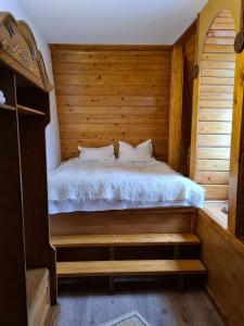ein Schlafzimmer mit einem Bett in einem Holzzimmer in der Unterkunft Villa Ramona SPA in Gura Humorului