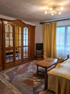 Zimmer mit einem Bett, einem Tisch und einem TV in der Unterkunft Villa Ramona SPA in Gura Humorului