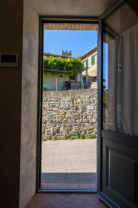 een open deur met uitzicht op een stenen muur bij Casa Mustiola in Montalcino