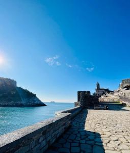 a stone wall next to the water with a castle at Vittoria 19 in Portovenere
