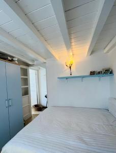 a bedroom with a white bed and a shelf on the wall at Vittoria 19 in Portovenere