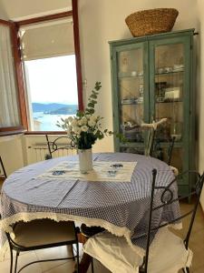 a dining room table with a vase of flowers on it at Vittoria 19 in Portovenere