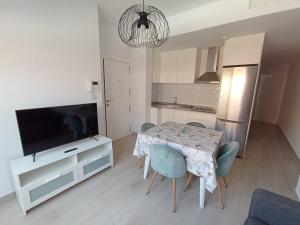 a living room with a table with chairs and a television at FUENGIROLA NEW APART. SWEET&BEACH in Fuengirola