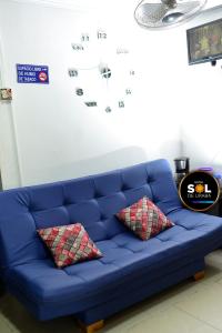 eine blaue Couch mit zwei Kissen in einem Zimmer in der Unterkunft Hotel sol de uraba in Apartadó