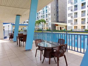 een patio met een tafel en stoelen naast een zwembad bij PacificSuites PH in Dasag