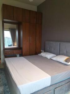 a bedroom with a large white bed with wooden cabinets at Apartment with Pool & Gym in Colombo