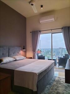 a bedroom with a large bed and a large window at Apartment with Pool & Gym in Colombo