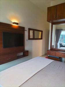 a bedroom with a bed and a flat screen tv at Apartment with Pool & Gym in Colombo