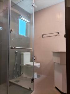 a bathroom with a glass shower with a toilet at Apartment with Pool & Gym in Colombo
