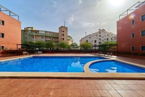 une grande piscine dans une ville avec des bâtiments dans l'établissement Ca Martina I Apartamento ideal con gran terraza cerca del mar, à Santa Pola