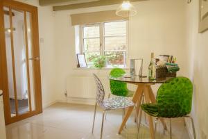 a dining room with a table and green chairs at Southwell Holiday Cottage - Lavender Cottage in Southwell +42 photos