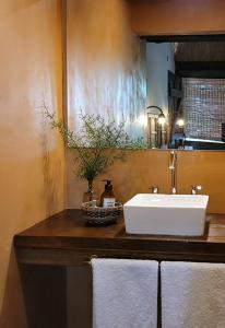 a bathroom with a sink and towels on a counter at La Saucina - Cabaña Rústica Chic in Tunuyán