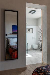 a mirror in a room with a bed and a bathroom at Casa Mustiola in Montalcino