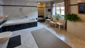 a bathroom with a tub and a toilet and a sink at 103 m2 Apartment EschenWald vomLandl Leogang in Leogang +28 photos