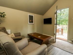 ein Wohnzimmer mit einem Sofa und einem Tisch in der Unterkunft Pheasant in Carthorpe