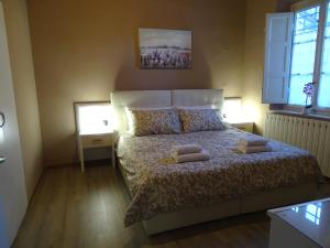1 dormitorio con 1 cama con 2 almohadas en Affittacamere Arancio, en Lucca
