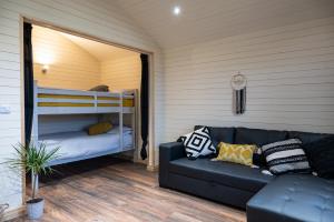 sala de estar con sofá y litera en The Buzzard - 6 Person Family Glamping Cabin, en Dungarvan