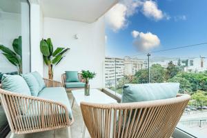a balcony with chairs and a table and a large window at INF25E- Tastefully furnished flat, Estepona center in Estepona