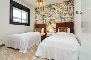 two beds in a room with a wall mural at INF25E- Tastefully furnished flat, Estepona center in Estepona +44 photos