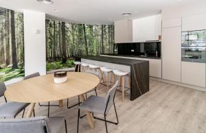 a kitchen with white cabinets and a wooden table and chairs at INF25E- Tastefully furnished flat, Estepona center in Estepona