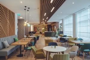 um restaurante com mesas e cadeiras e um átrio em Holiday Inn Skopje, an IHG Hotel em Skopje