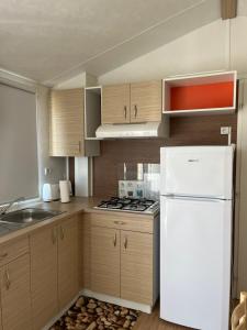 a kitchen with wooden cabinets and a white refrigerator at Hospedaria O Castelo in Portel
