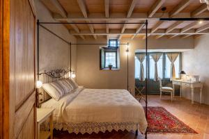 een slaapkamer met een hemelbed en een bureau bij Casa Mustiola in Montalcino