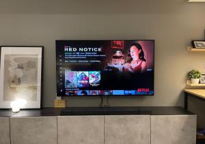 a flat screen tv on a wall in a living room at 8 Sun Staycation in Manila