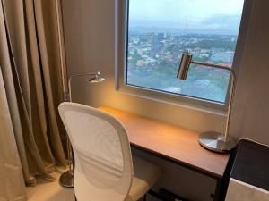 a desk with a white chair and a window at 8 Sun Staycation in Manila