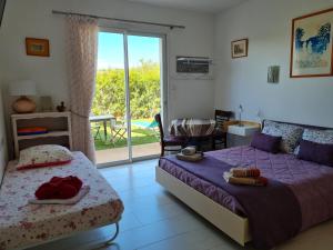 1 dormitorio con 2 camas y balcón en Chambres d'hôtes B&B La Bergeronnette avec piscine couverte chauffée en Bizanet