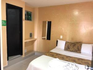 a small bedroom with two beds and a window at Ayenda Hotel Ecosuite Quibdó in Quibdó